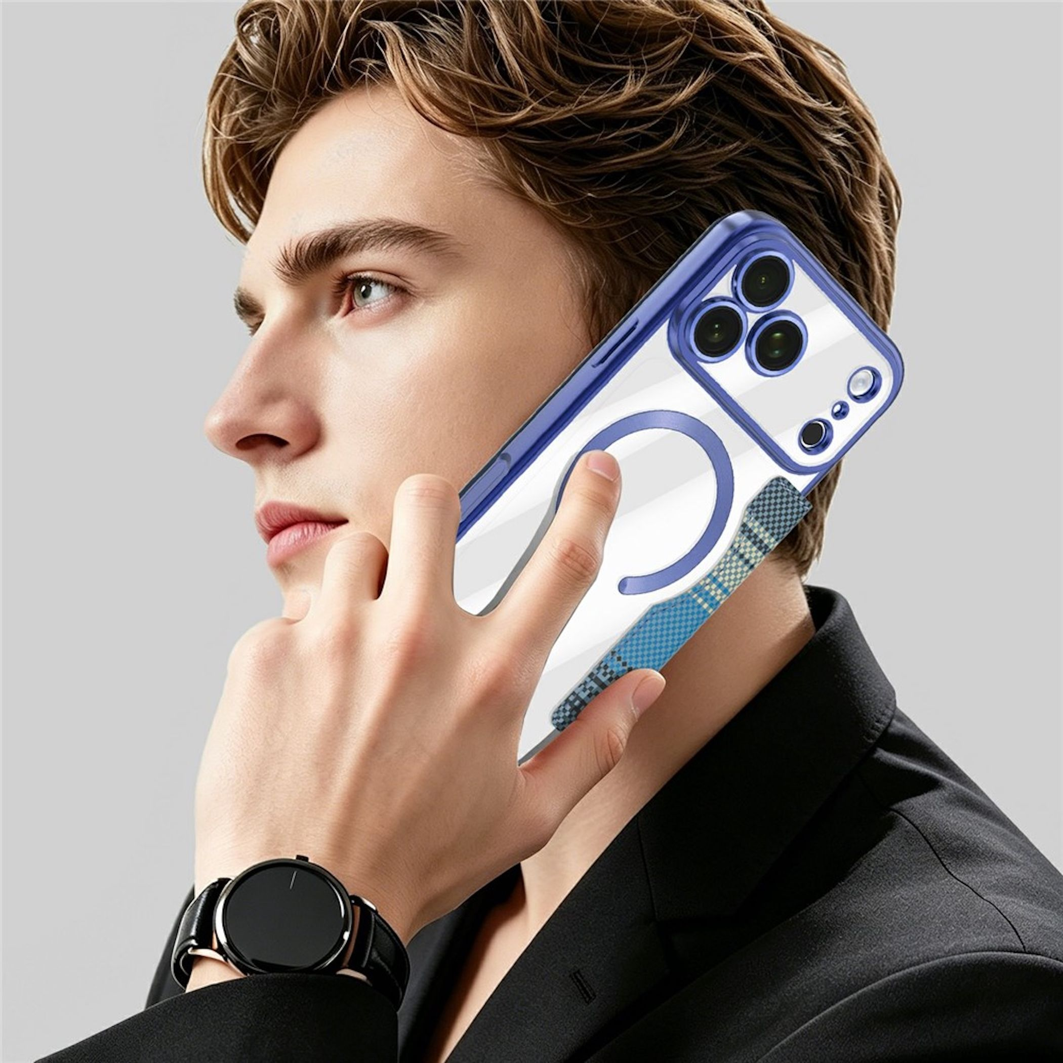 Ein Mann mit schwarzem Anzug telefoniert und hält ein blau-klares Smartphone mit Ringhalter am Ohr.