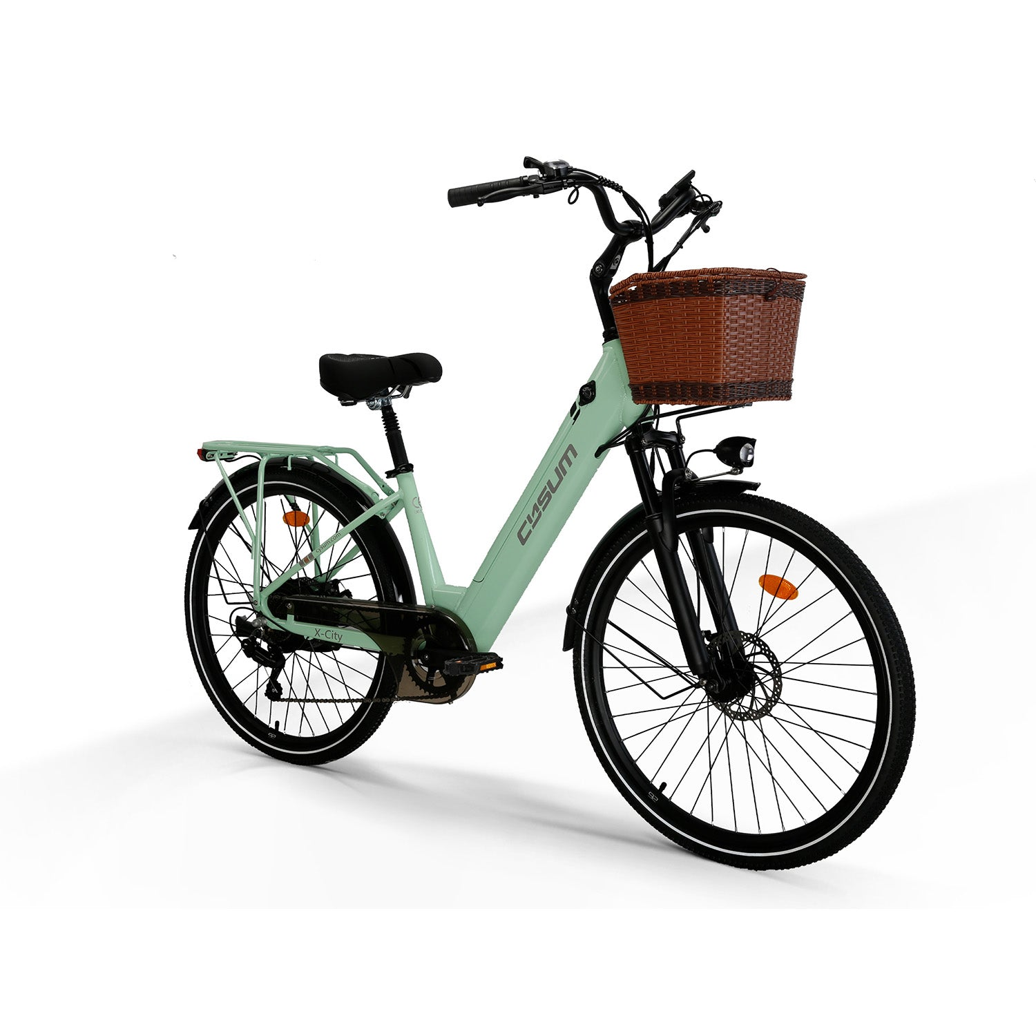 Una bici elettrica da città verde chiaro con cesto in vimini marrone davanti su sfondo bianco.