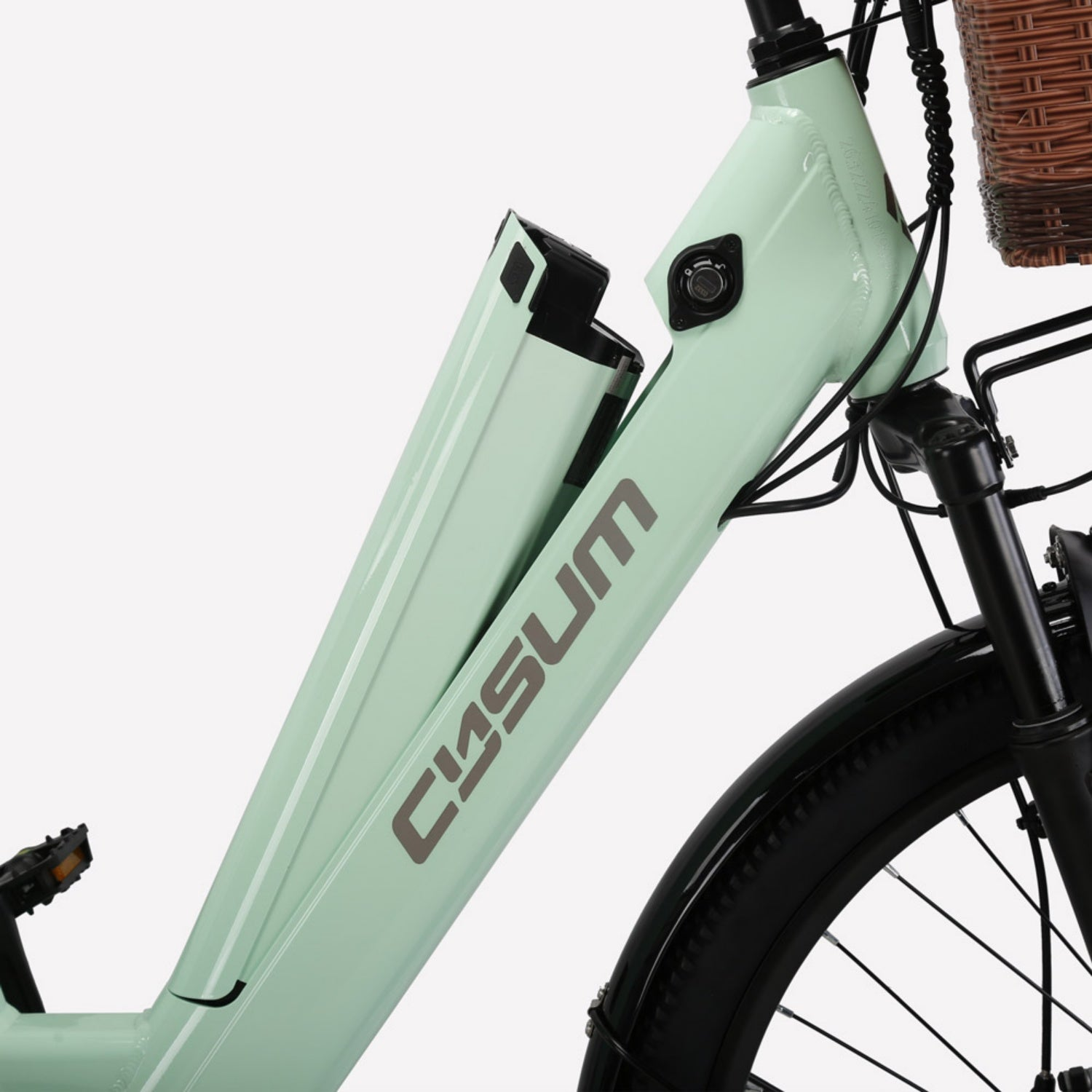 Telaio e-bike verde chiaro con batteria parzialmente rimossa, cestino marrone e ruota anteriore.