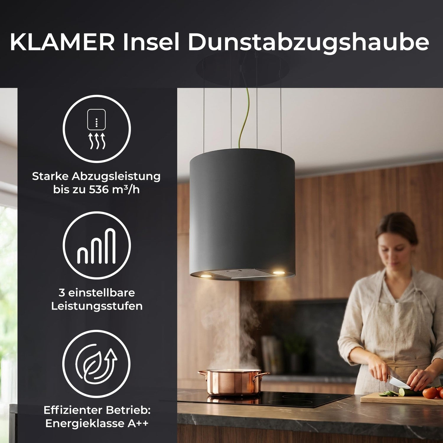 Schwarze KLAMER Insel Dunstabzugshaube über einer Küche, während eine Frau Gemüse schneidet.