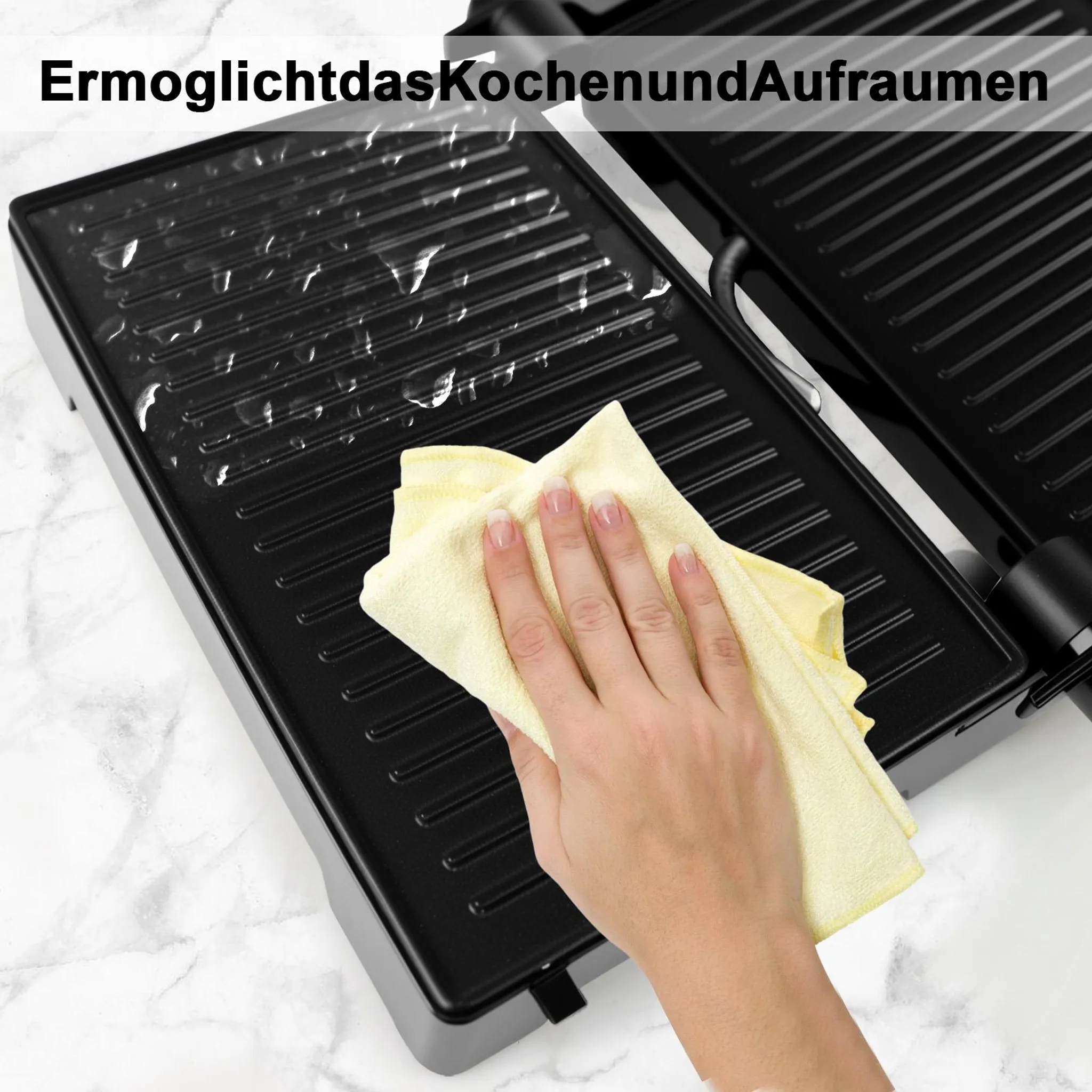 Eine Hand reinigt die gerippte Platte eines Kontaktegrills mit einem gelben Tuch.