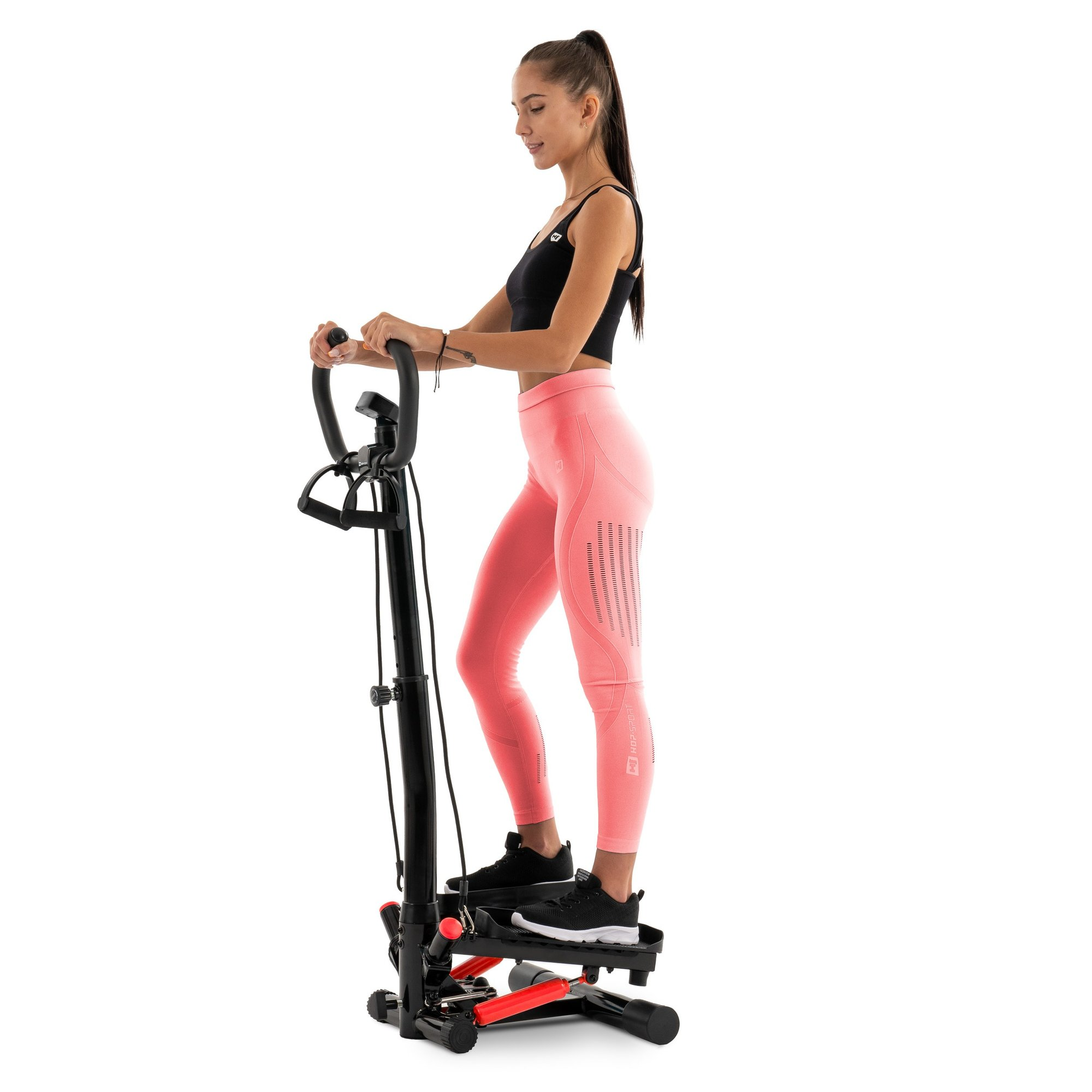 Eine Frau in Sportkleidung trainiert auf einem schwarzen Heimtrainer mit roten Akzenten.