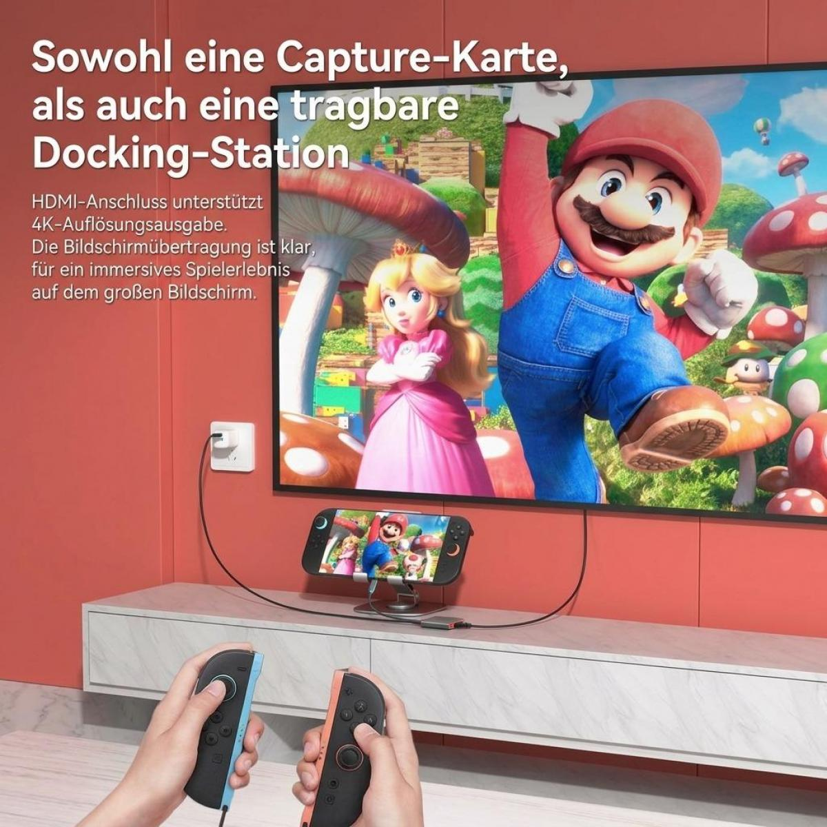 Eine Dockingstation verbindet eine Spielekonsole mit einem Fernseher, auf dem ein Mario-Spiel läuft, und zwei Controller.