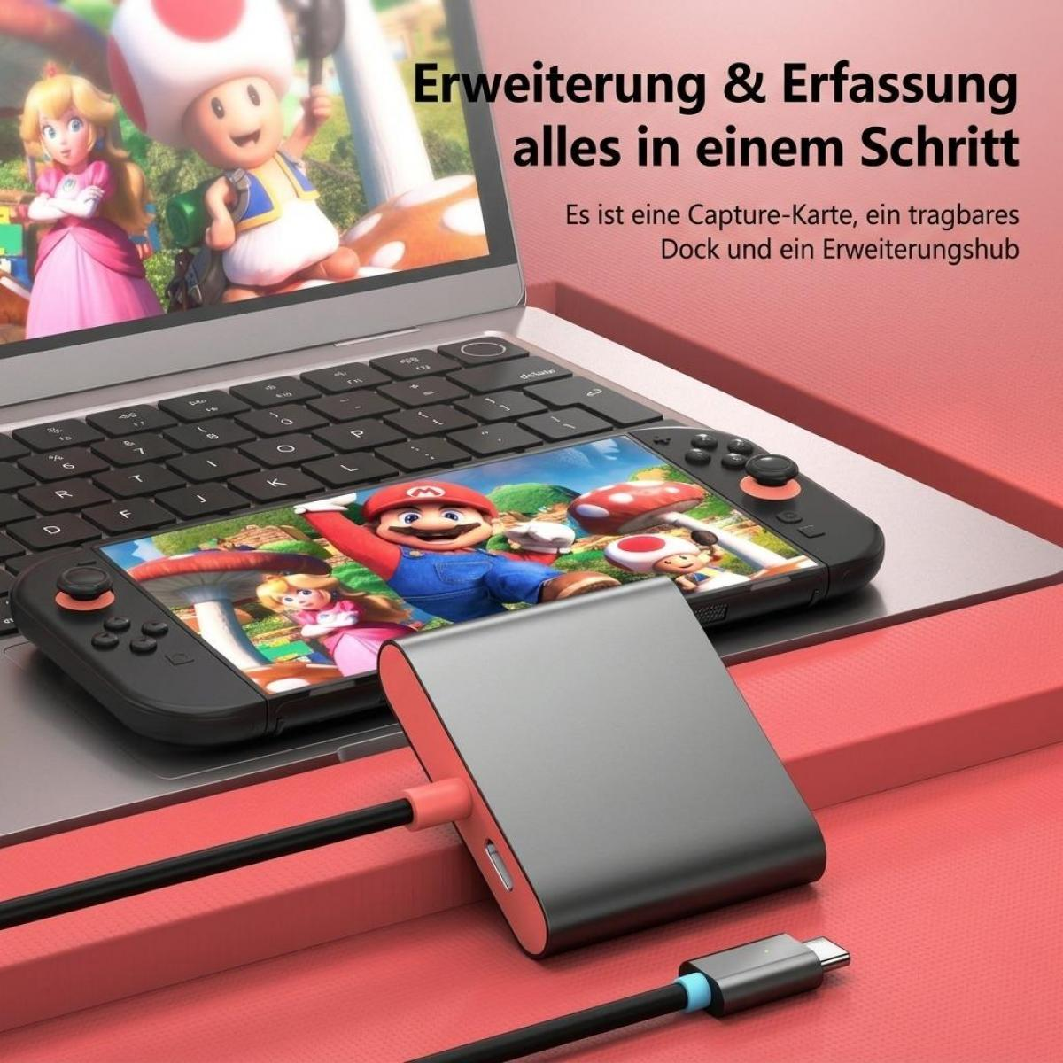 Eine Capture-Karte und ein Dock vor einem Laptop, mit einem Videospiel auf dem Bildschirm.