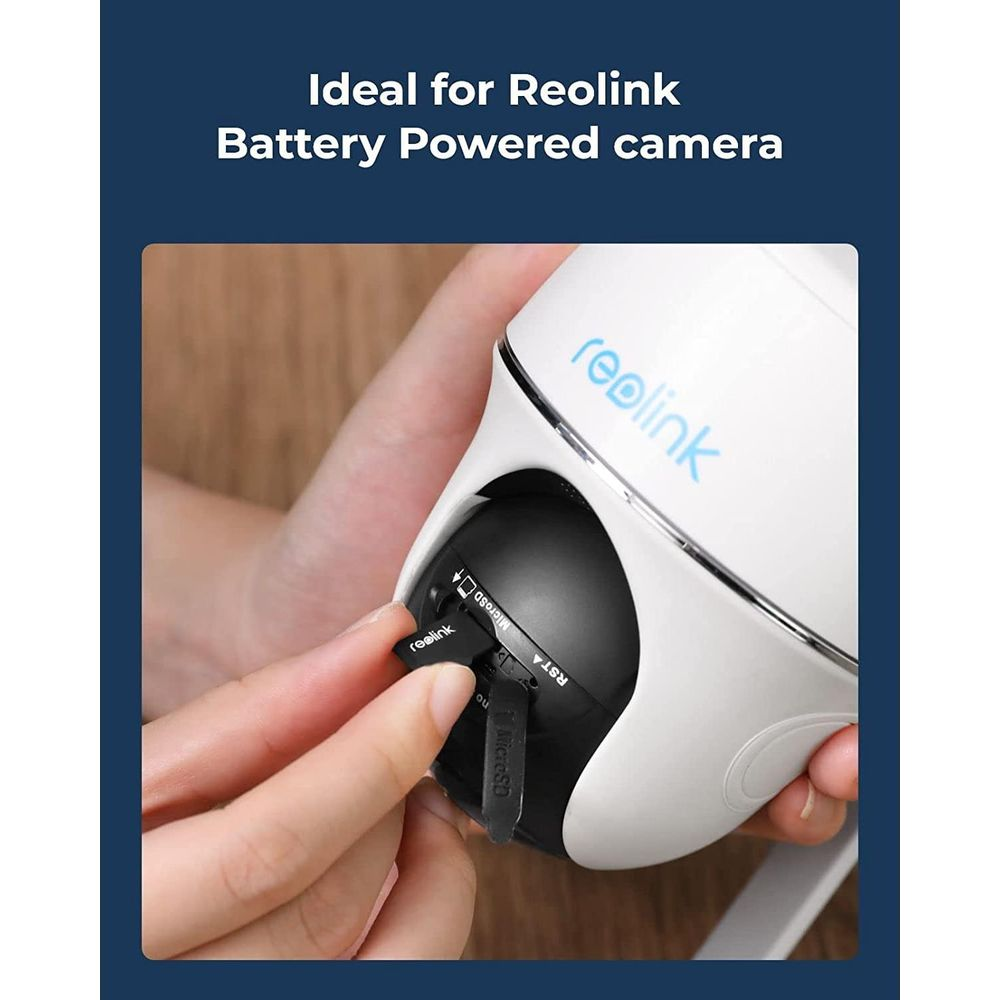 Une main insère une carte micro SD dans une caméra Reolink blanche.