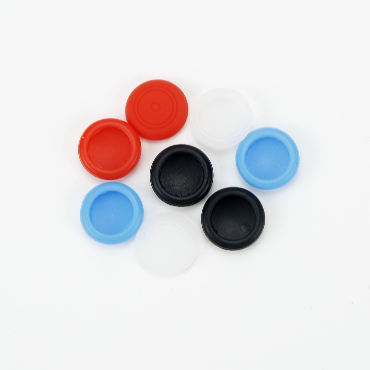 Sette colorati cappucci per joystick analogici sono disposti su una superficie bianca.