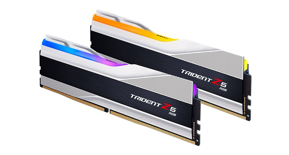 Dos módulos de RAM G.SKILL Trident Z5 RGB con disipadores plateados y negros y tiras de luz brillante sobre fondo blanco.