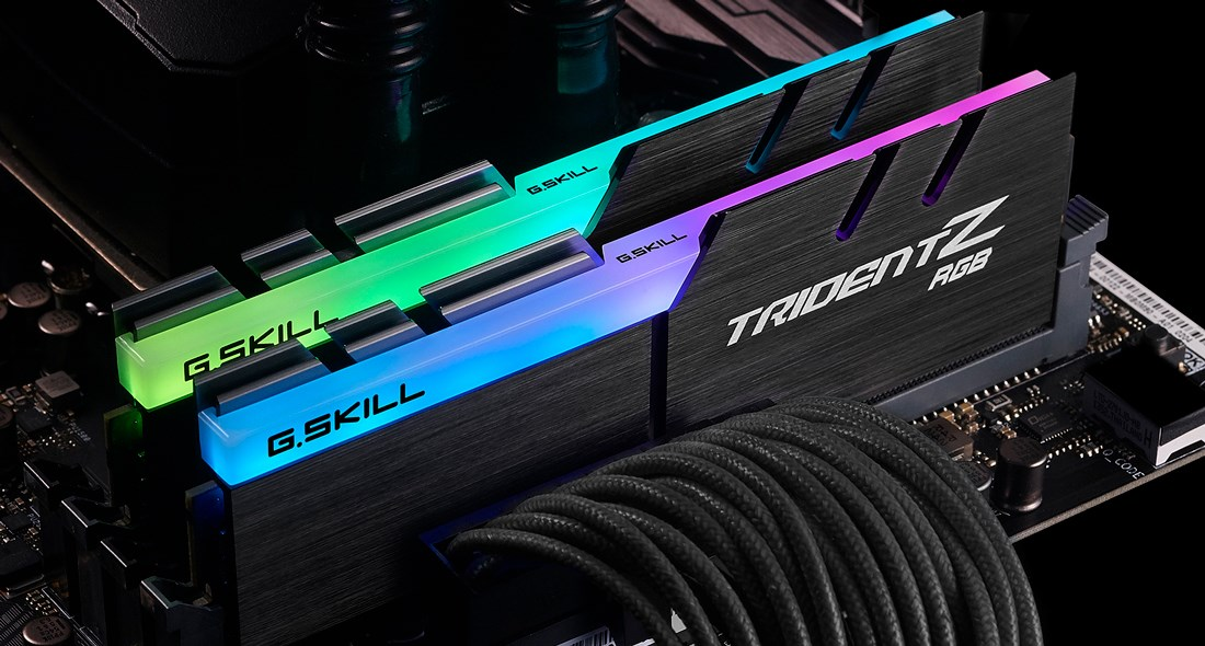 Deux barrettes de RAM G.Skill Trident Z RGB avec éclairage vert et bleu sur une carte mère.