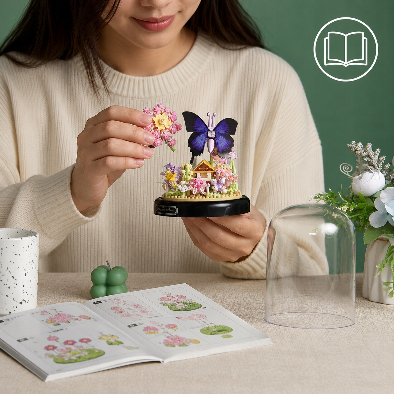 Kobieta składa miniaturowy model z motylem i kwiatami na stole.