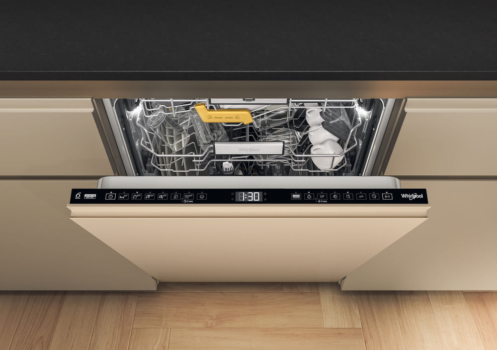 Lavavajillas Whirlpool abierto integrado en cocina beis con suelo de madera.