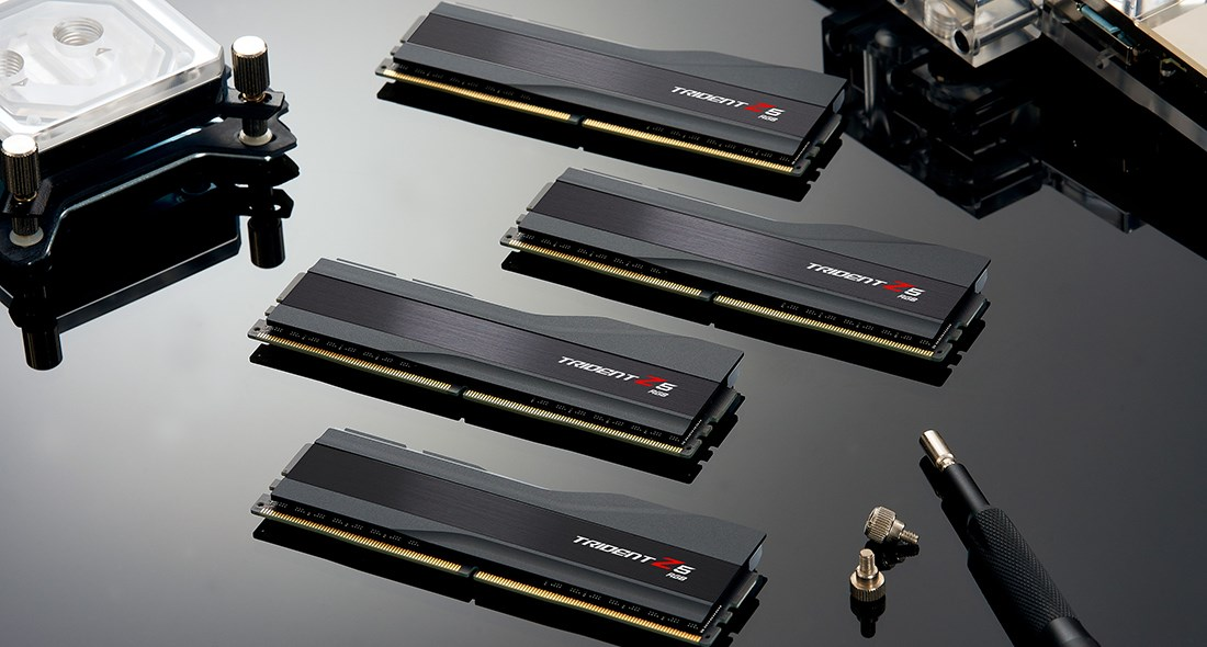 Cuatro módulos de memoria RAM Trident Z5 RGB negros dispuestos en diagonal sobre una superficie brillante.