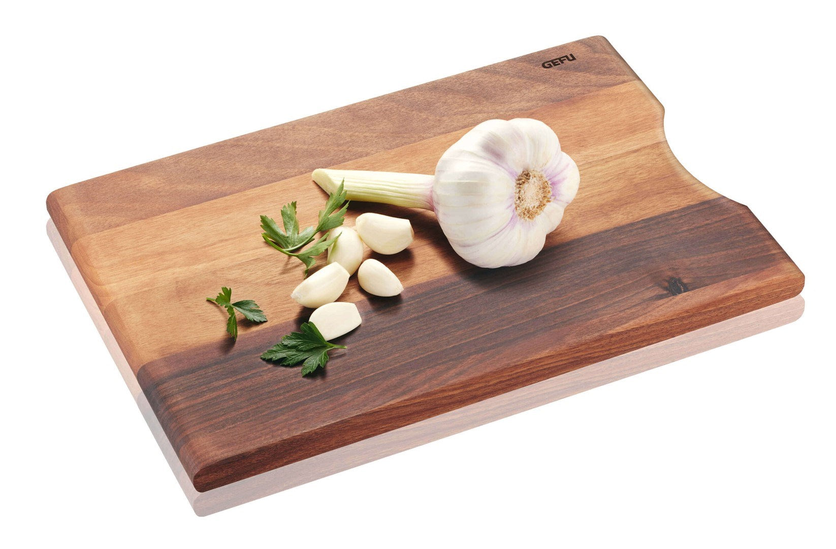 Frischer Knoblauch und Petersilie liegen auf einem Holzschneidebrett.