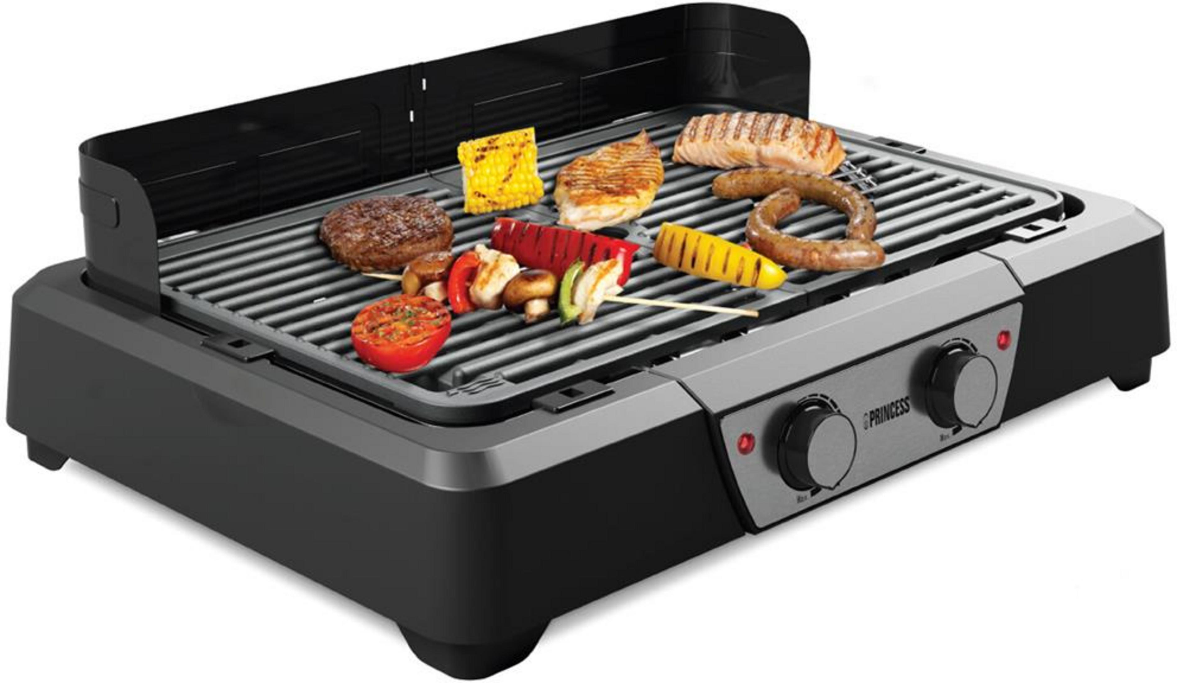 Ein elektrischer Tischgrill mit Fleisch, Würstchen und Gemüse auf dem Grillrost.