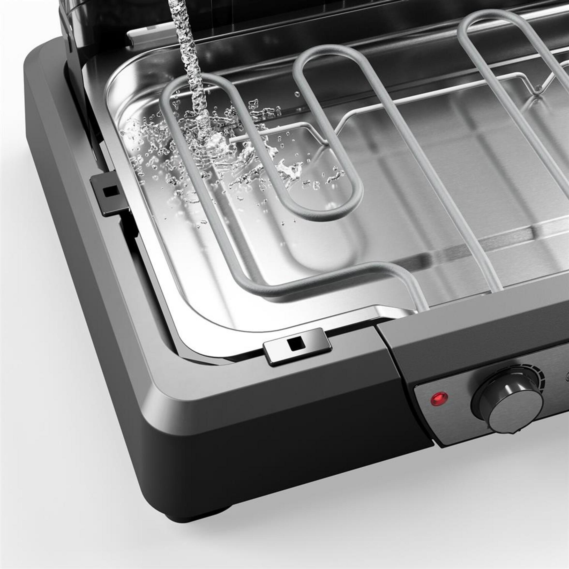 Wasser wird in die Edelstahl-Fettwanne eines Elektrogrills mit Heizelementen gegossen.
