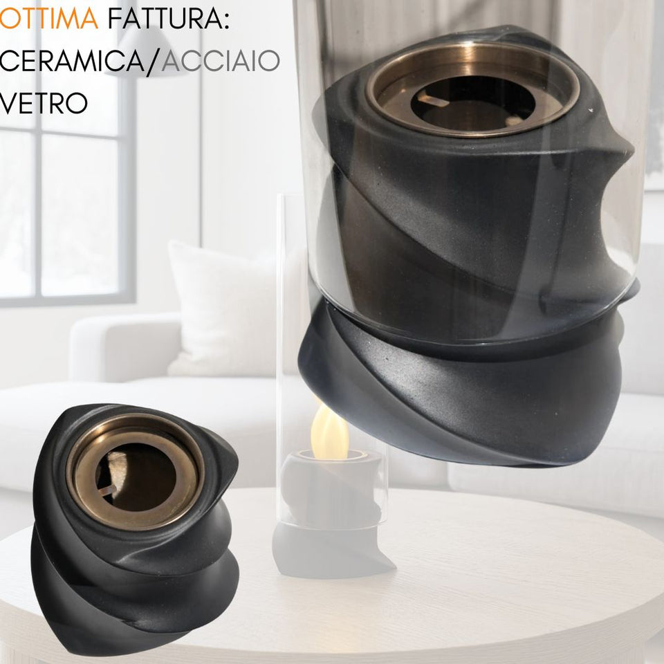 Una lampada ad olio in ceramica nera con cilindro in vetro su un tavolo.