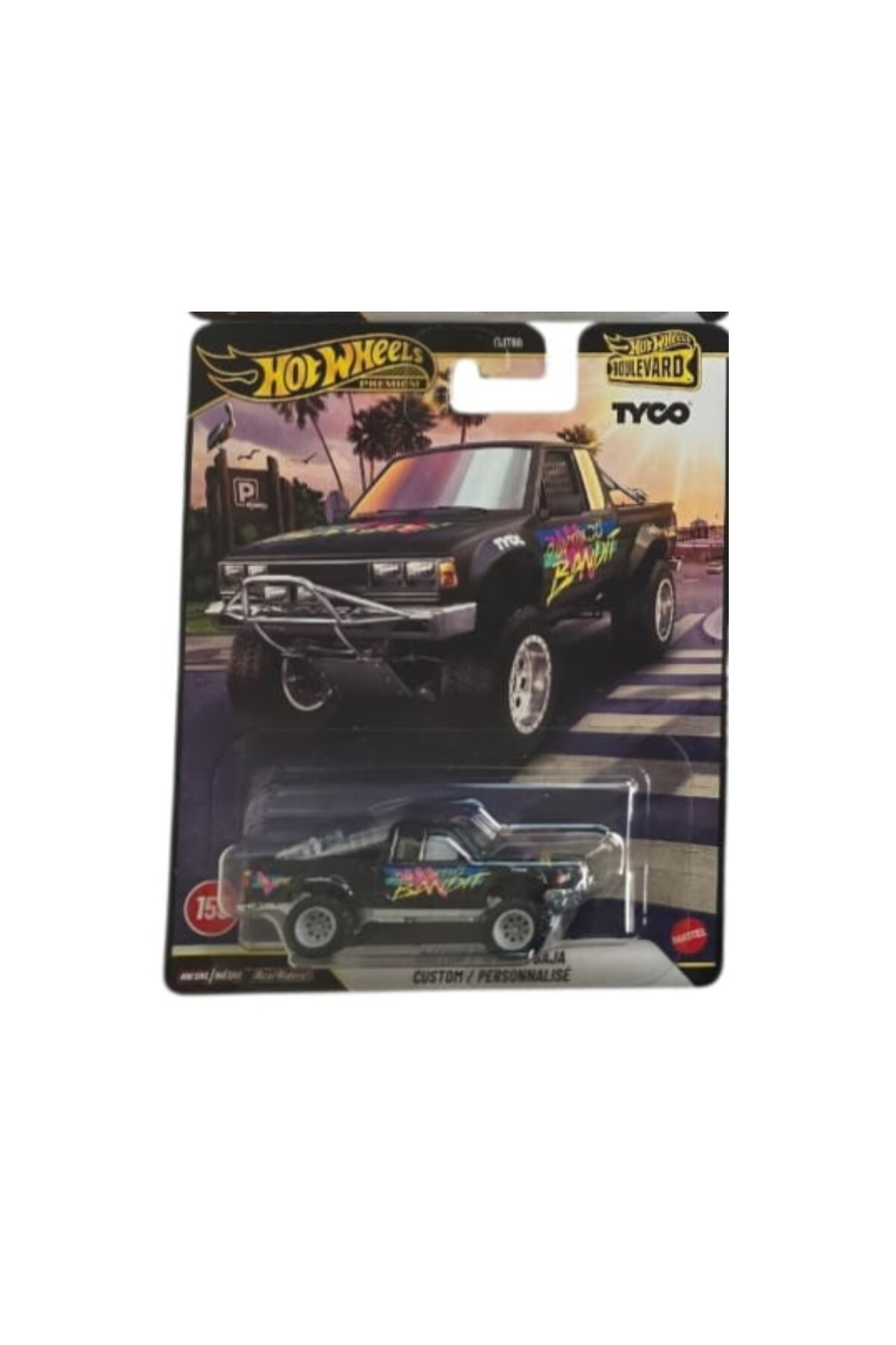 Tropik arkaplanlı ambalajında Hot Wheels Premium Tyco Custom Baja kamyonet.