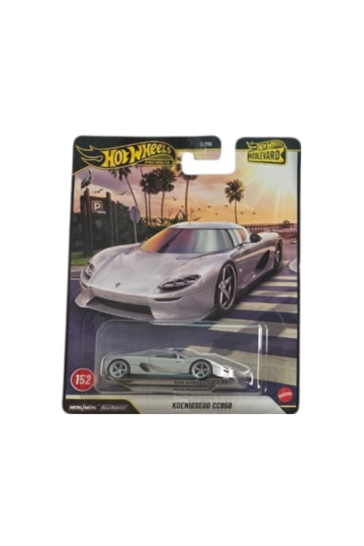 Tropikal bir arka plana sahip, gümüş renkli Koenigsegg CC850 oyuncak araba içeren bir Hot Wheels Premium Boulevard paketi.