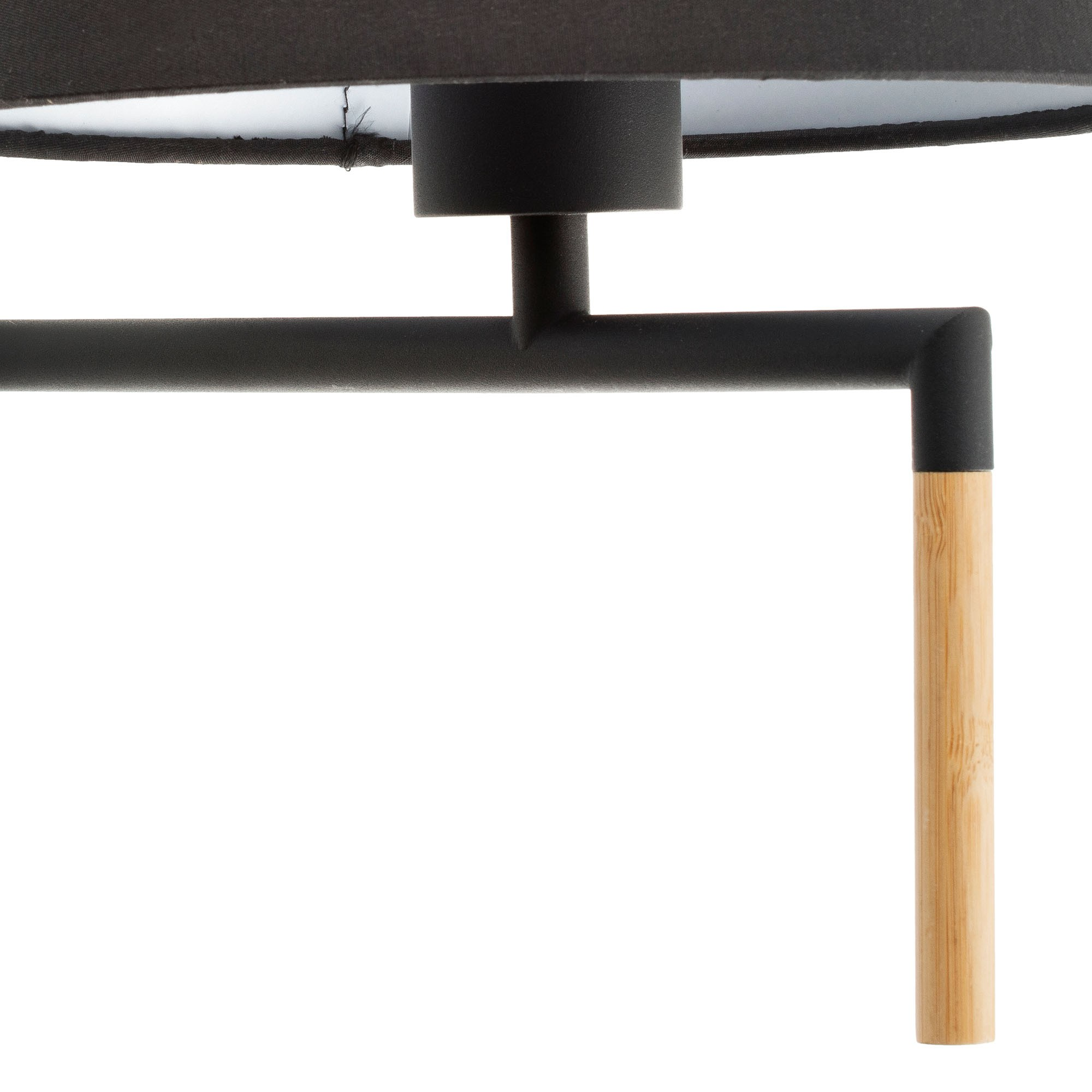 Primo piano di una moderna lampada nera con gamba in legno e paralume nero.