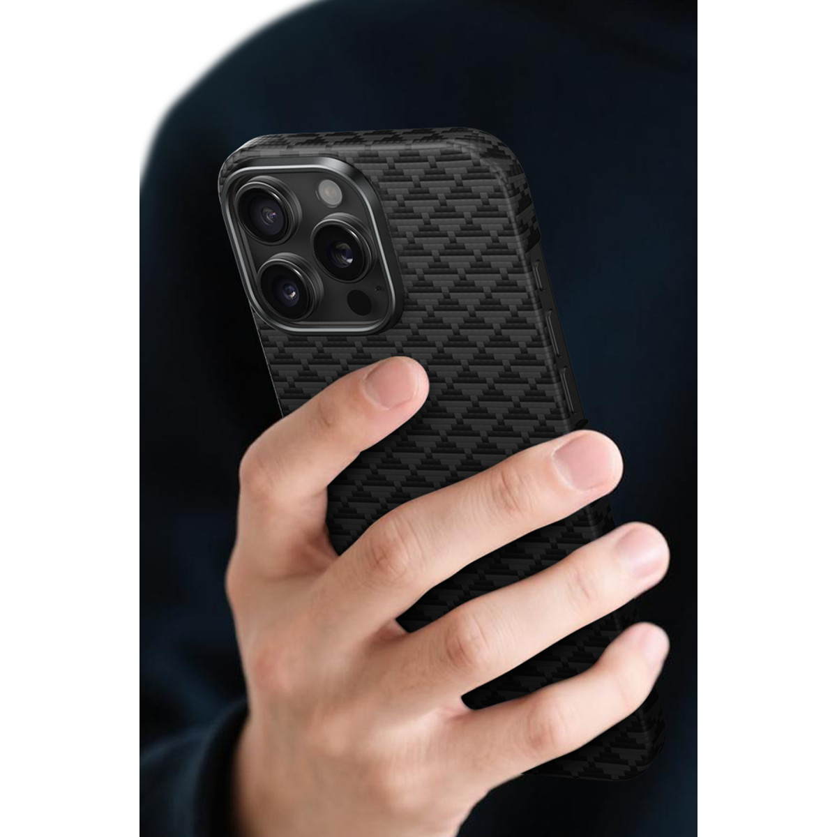 Bir el, karbon desenli ve üçlü kameralı siyah bir akıllı telefon tutuyor.