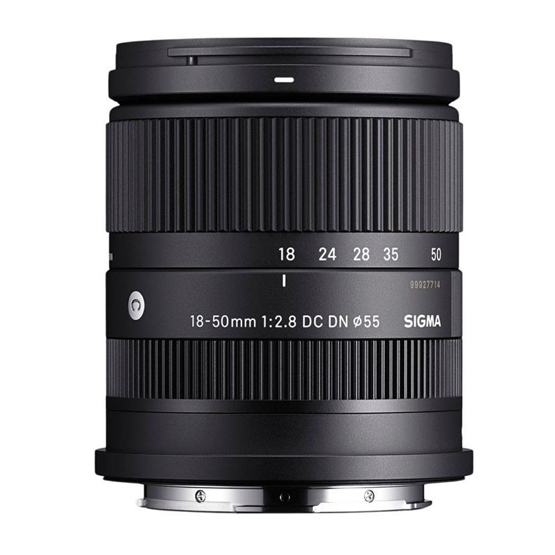 Obiettivo per fotocamera nero Sigma 18-50 mm f/2.8 DC DN con anelli scanalati e scritta bianca su sfondo bianco.