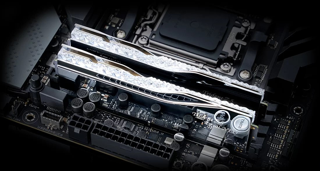Deux barrettes de RAM Trident Z5 argentées au design cristal sur une carte mère noire.