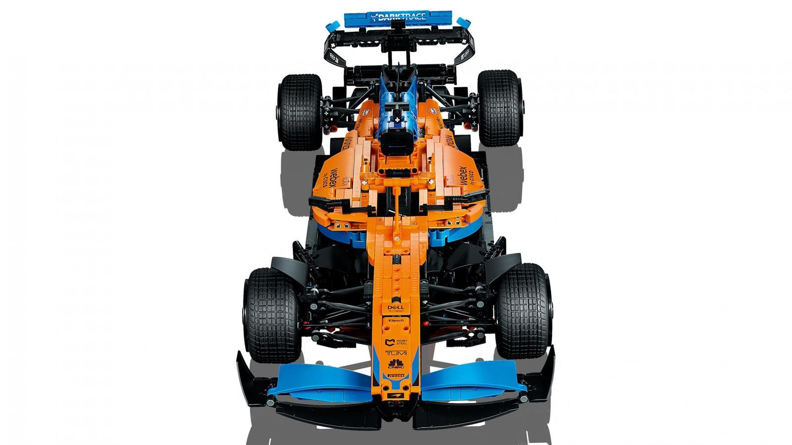 Ansicht von oben auf ein orange-blaues Lego Formel-1-Rennauto-Modell auf weißem Hintergrund.