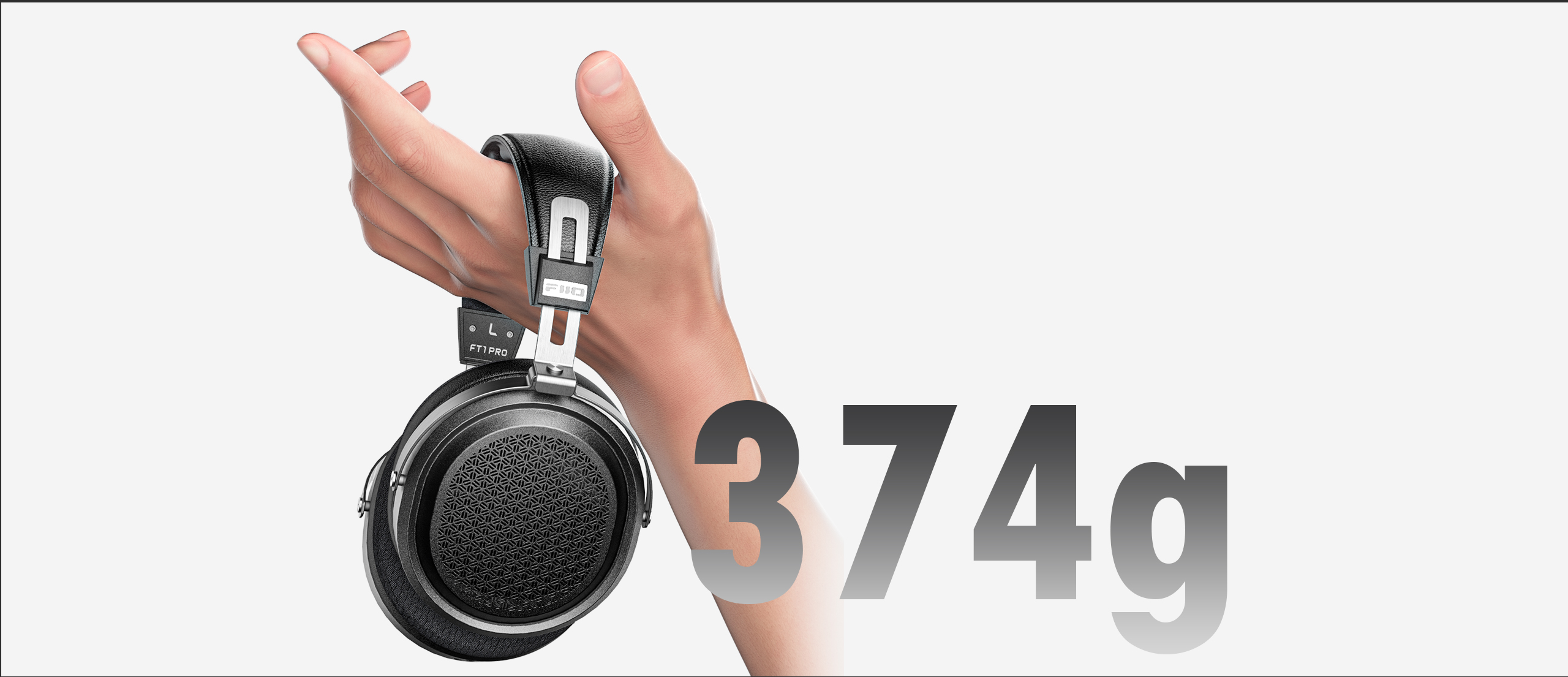 Dłoń trzyma czarne słuchawki nauszne, obok widnieje napis 374g.