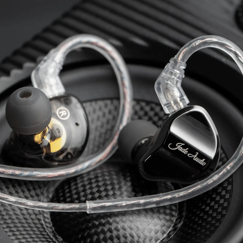 Dokanałowe słuchawki Jade Audio z przezroczystymi kablami na membranie głośnika.