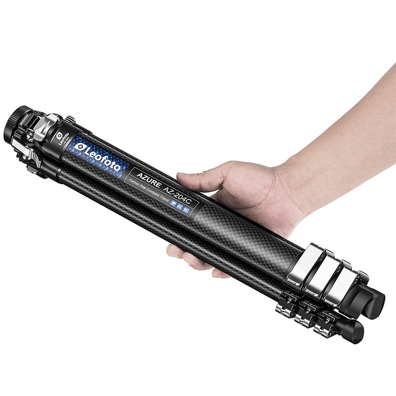 Eine Hand hält ein kompaktes Leofoto Azure AZ-204C Carbon-Stativ auf weißem Hintergrund.
