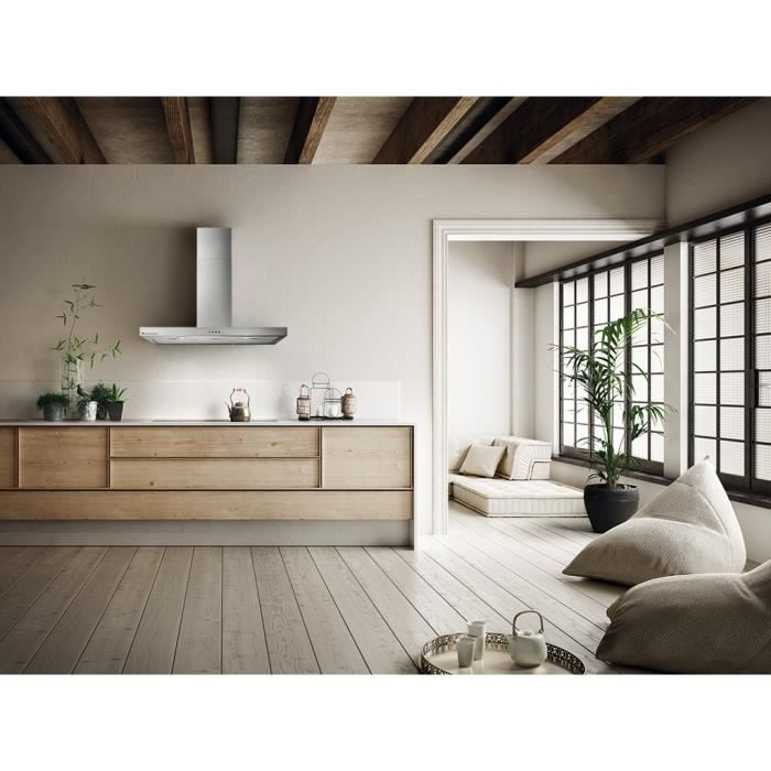 Cocina moderna con armarios de madera, campana extractora, plantas y sala luminosa al fondo.