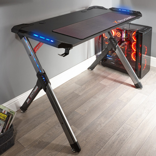 Schwarzer Gaming-Schreibtisch mit blauer LED-Beleuchtung und PC-Gehäuse mit roter Beleuchtung.