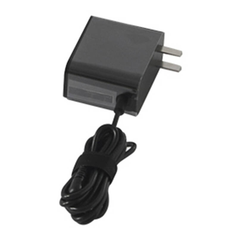 Un adaptador de corriente negro con dos clavijas metálicas y un cable enrollado ordenadamente sobre fondo blanco.