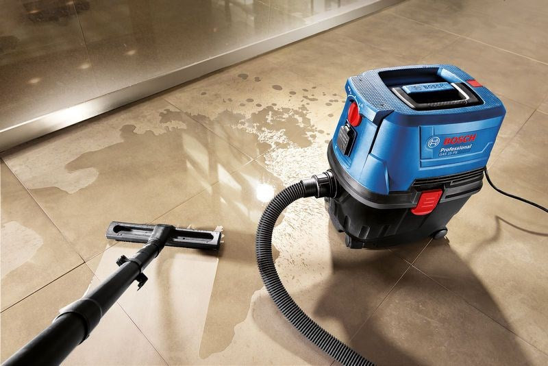 Un aspirapolvere professionale blu Bosch pulisce pavimenti bagnati.