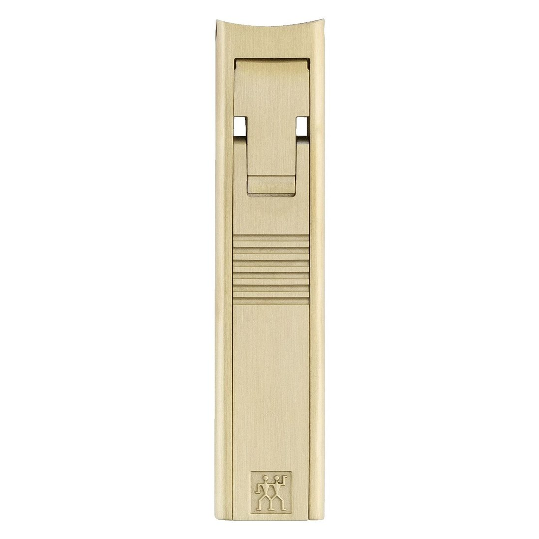 Goldfarbener, eleganter Nagelknipser im Etui mit feinen Linien und Markenlogo.