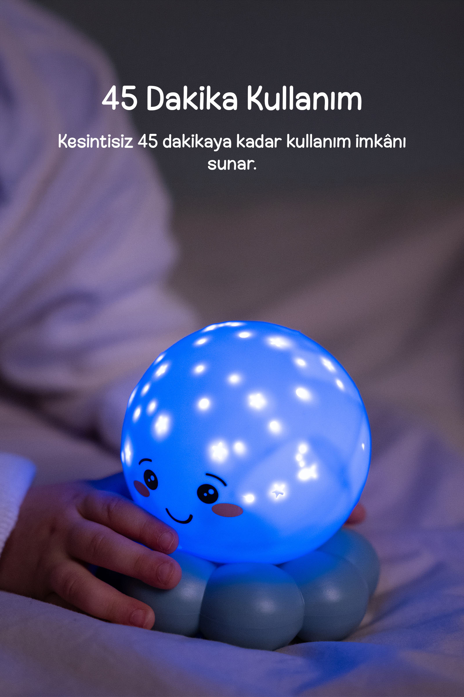 Bir el, yüzü olan mavi ve yıldızlı bir gece lambasını tutuyor.