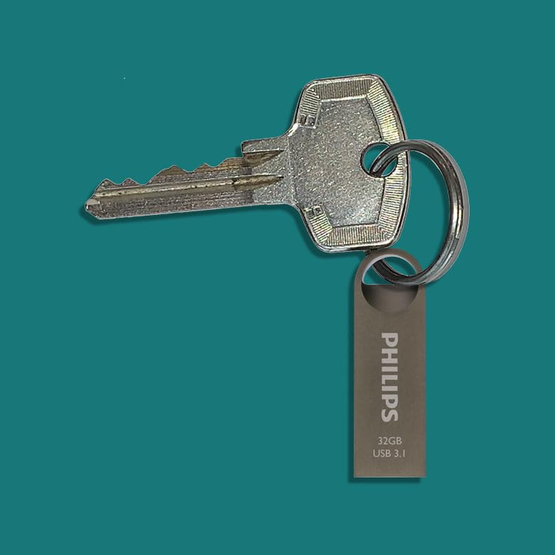 Een zilveren sleutel en een grijze Philips USB-stick hangen samen aan een ring tegen een blauwe achtergrond.