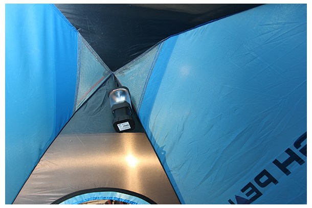 Innenansicht eines blau-schwarzen Zeltes mit einer kleinen schwarzen Laterne an der Decke.