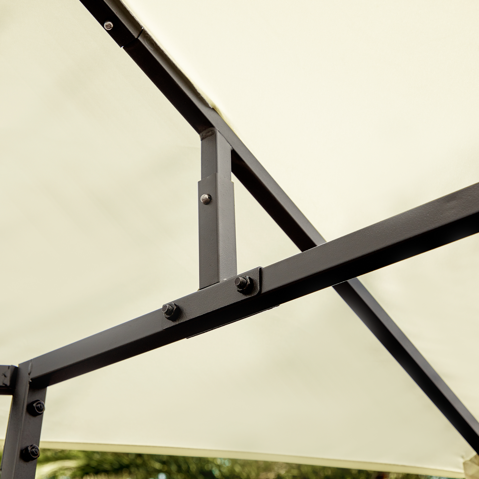 Primer plano de la estructura de metal negro de un cenador beige, asegurada con pernos.