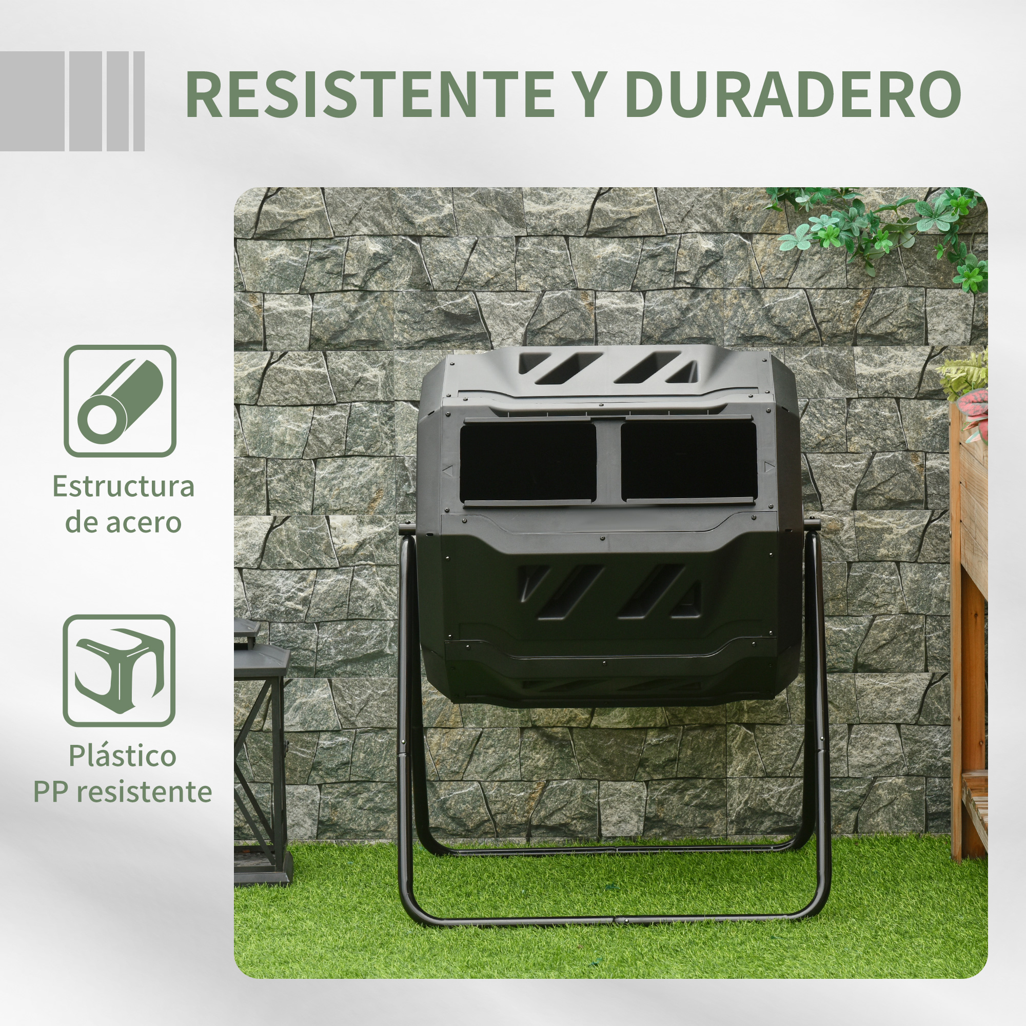 Un compostador negro en un soporte de metal frente a una pared de piedra gris y césped verde.