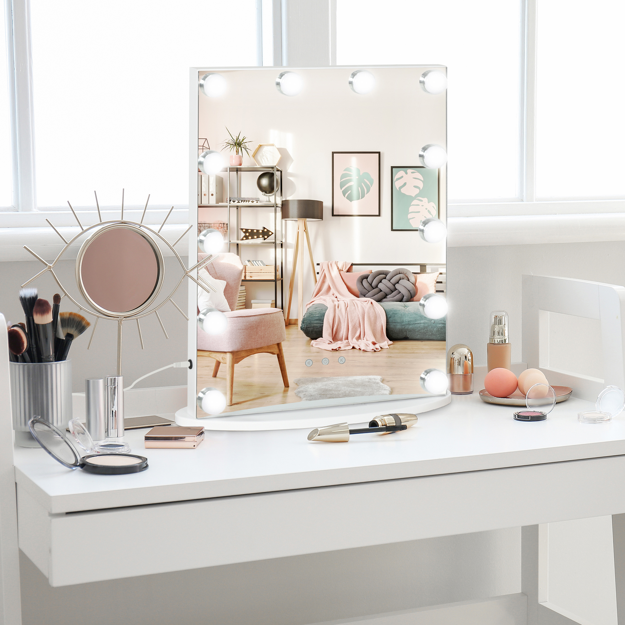 Un espejo de tocador iluminado en una mesa blanca con artículos de maquillaje y reflejo de la habitación.