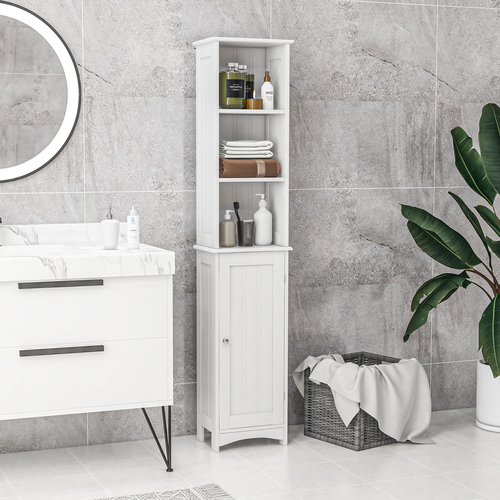 Un armario de baño blanco se encuentra entre un lavabo y una planta frente a azulejos grises.