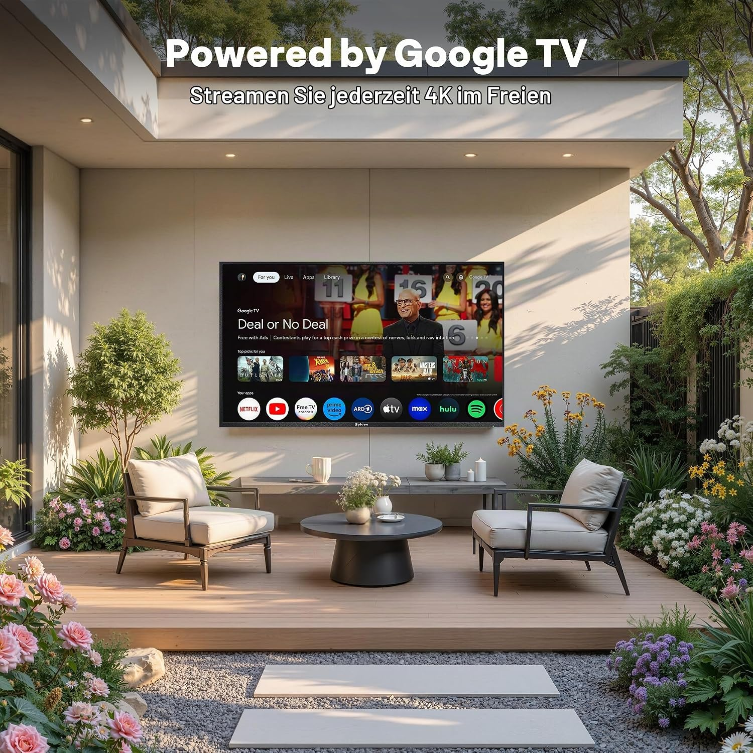 Moderno patio de jardín con Google TV, sillones cómodos, suelo de madera y frondosos macizos de flores.