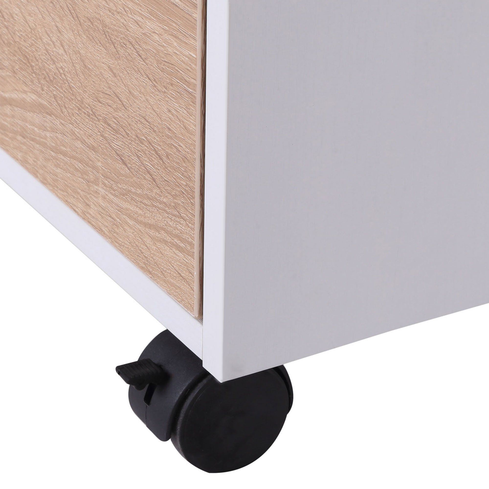 Un cuerpo de mueble blanco con frente de cajón de madera descansa sobre una rueda negra.