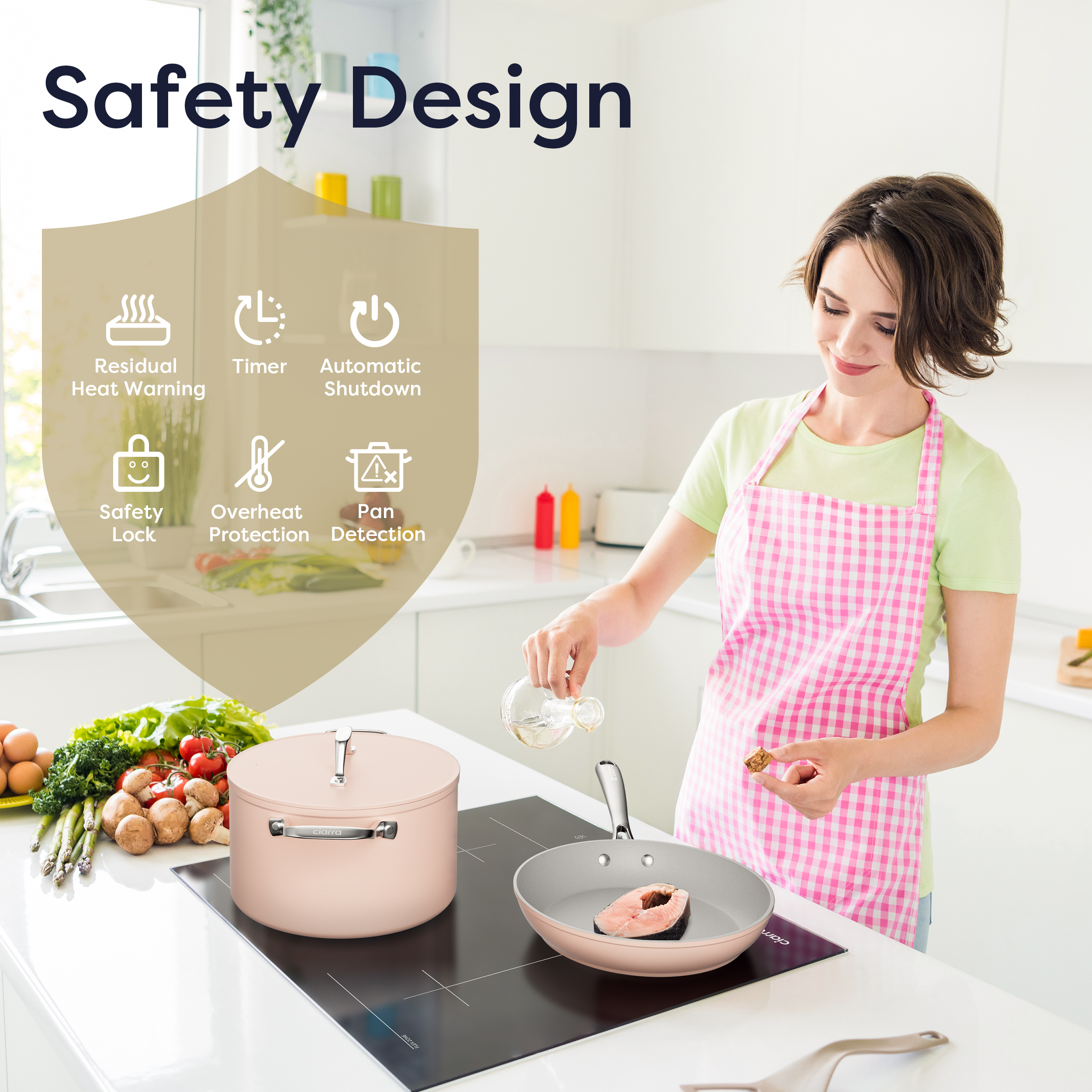 Mujer con delantal rosa cocina pescado en sartén sobre placa de inducción en cocina moderna.