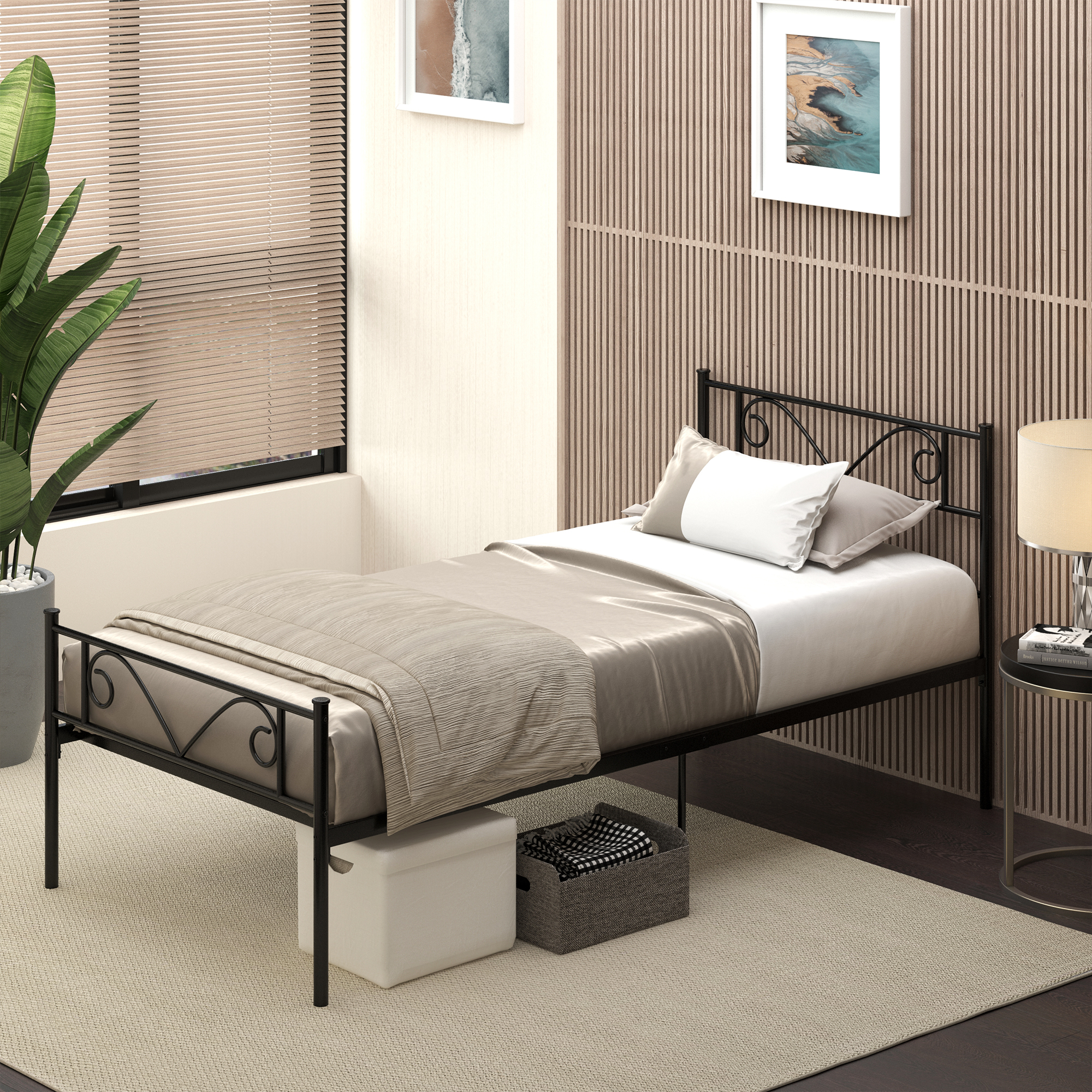 Cama individual de metal negro con ropa de cama beige, almohadas, cajas de almacenamiento debajo y una planta.