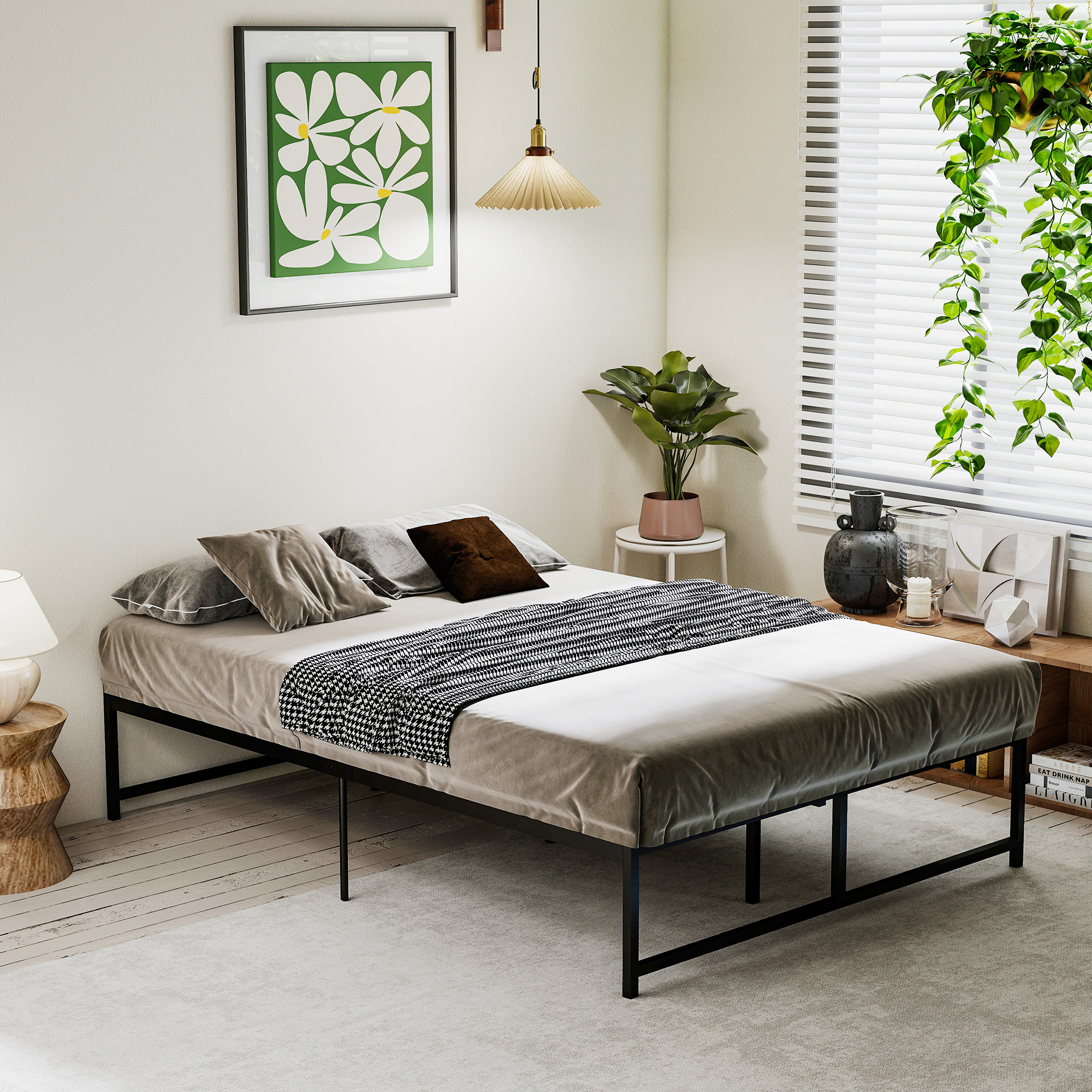 Acogedor dormitorio con cama de metal negro, arte floral en la pared y plantas colgantes en la ventana.