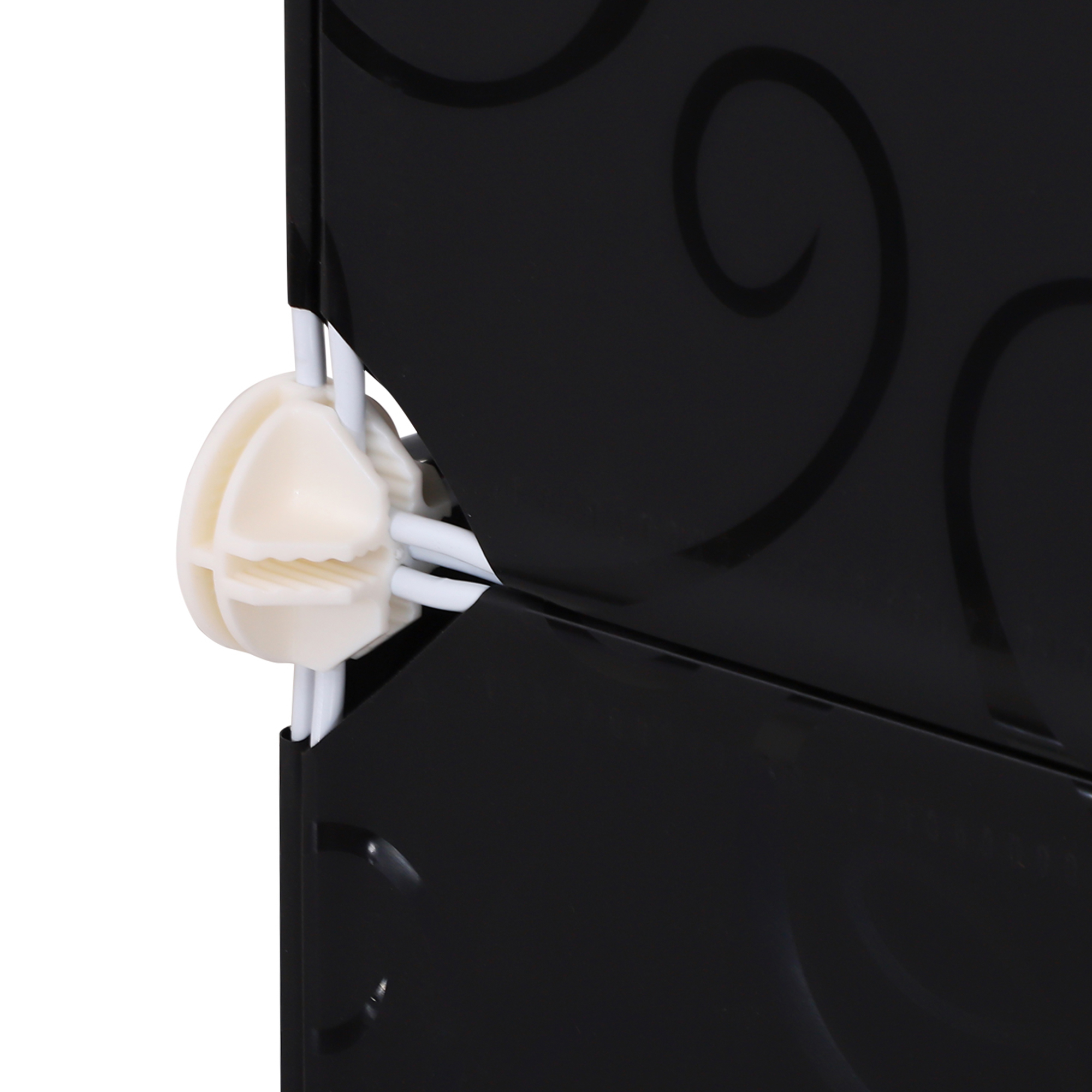 Primer plano de un conector de esquina de plástico blanco que sostiene paneles negros y varillas de metal.