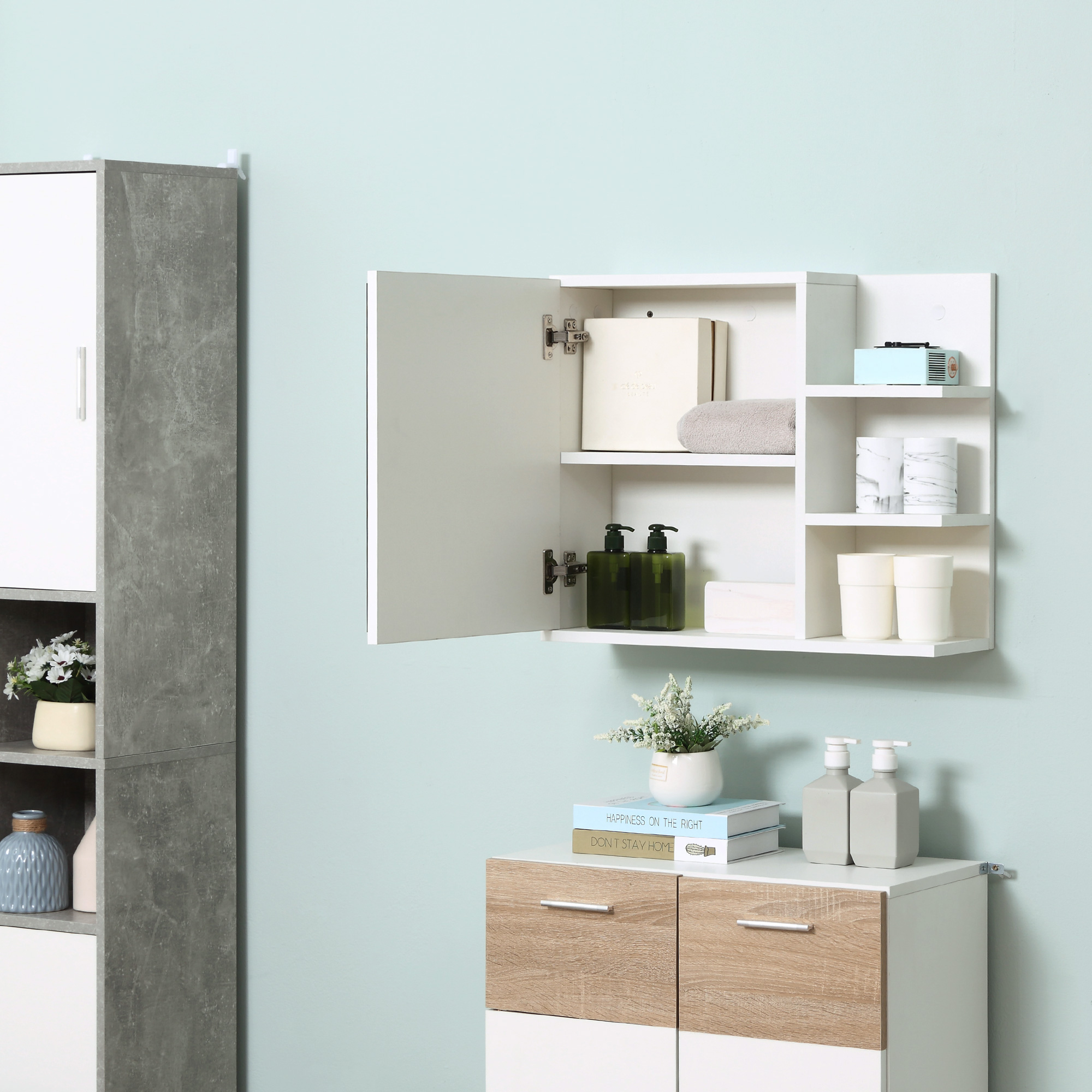 Un armario de pared blanco con puerta abierta, lleno de artículos de aseo, sobre un mueble blanco con cajones de madera.