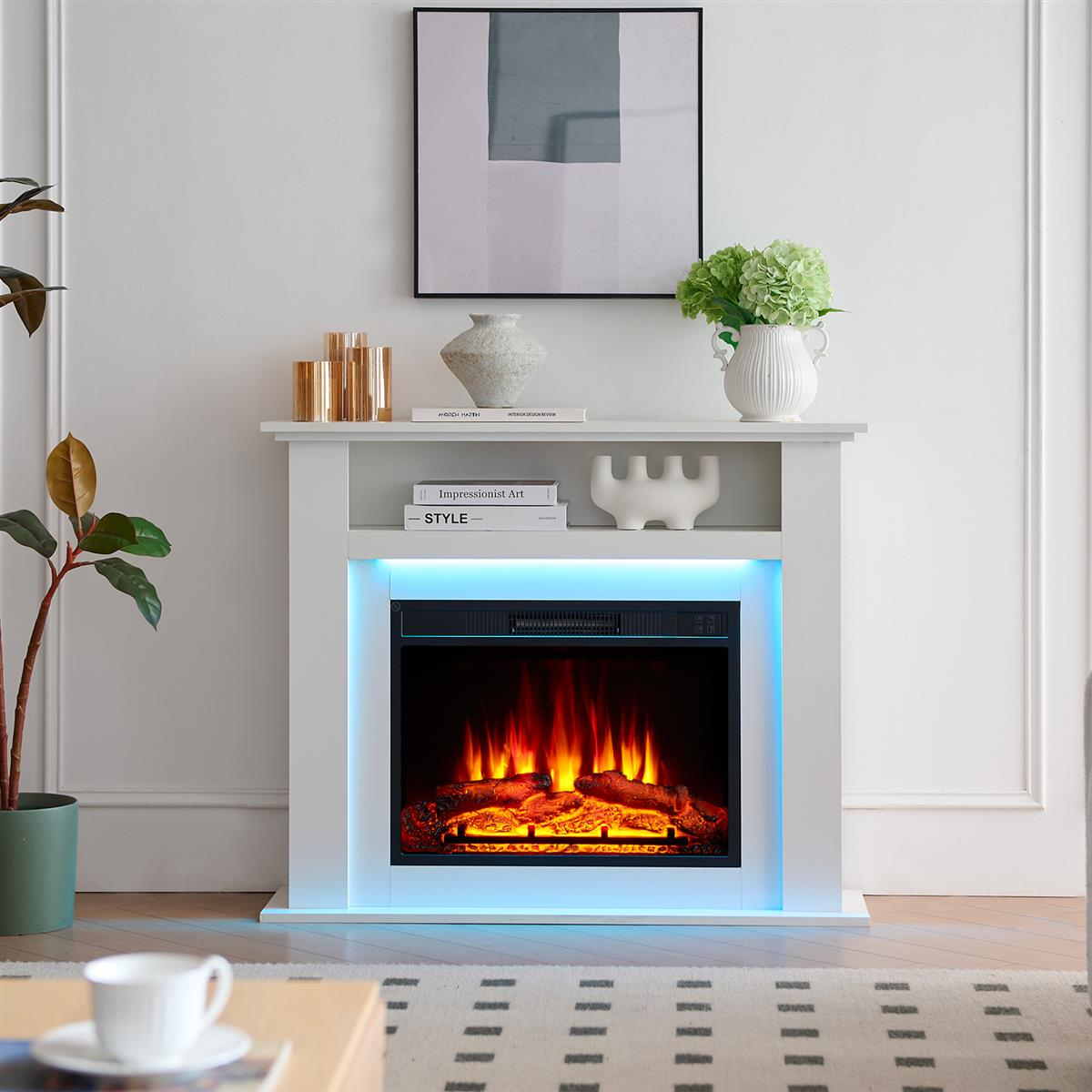Moderner weißer Kamin mit elektrischem Feuer und blauer LED-Beleuchtung, dekoriert mit Vasen und Kunst.