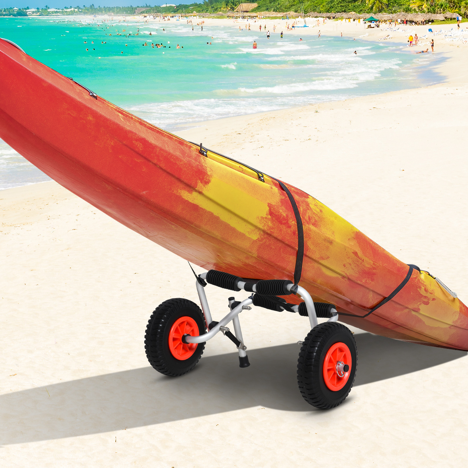 Un kayak rojo y amarillo en un carrito en una playa de arena con mar azul al fondo.